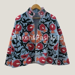 May include: A light blue jacket with a high collar and open front. The jacket is adorned with red and orange floral embroidery and black vines. The text "Plaksha Fashions" is visible on the bottom left of the jacket.