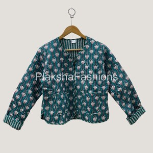 May include: A teal quilted jacket with a floral pattern in white and pink. The jacket has long sleeves with striped cuffs and a round neckline. The brand name "Plaksha Fashions" is visible in the image.
