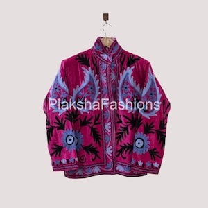 May include: A magenta jacket with intricate floral embroidery in black, light blue, and white. The jacket features a high collar and is hanging on a wooden hanger. The text "PlakshaFashions" is visible.