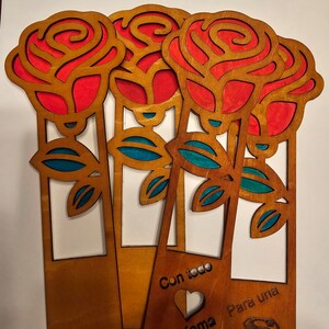 May include: Four wooden rose bookmarks with red and blue paint. The bookmarks have the text "Con todo Mama" and "Para una" with a heart and a superman symbol.