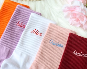 May include: Five pairs of socks in different colors with embroidered names: Julia, Alice, Charlotte, Sophia. The socks are arranged in a row from left to right.