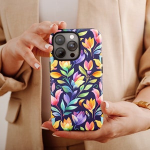 a woman holding a cell phone with a colorful flower pattern