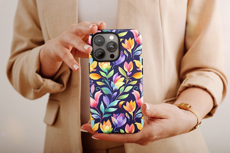 a woman holding a cell phone with a colorful flower pattern
