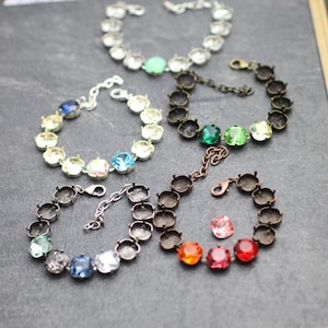 May include: Five bracelets with different coloured stones and metal settings. The bracelets are made of silver and copper metal. The stones are clear, light blue, green, red, and orange.