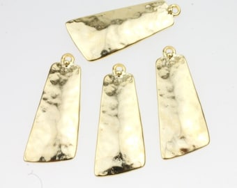 May include: Four gold-toned metal pendant charms with a hammered texture. The charms are rectangular with rounded corners and have a hole at the top for attaching to a chain or cord.