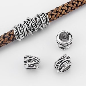 May include: Silver metal beads with a braided rope design. The beads are in various sizes and shapes, and they are perfect for making jewelry or other crafts.