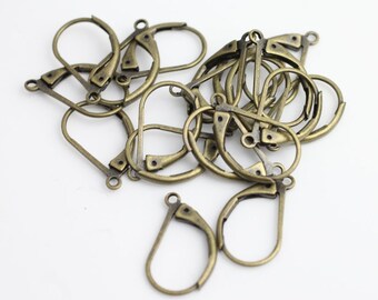 May include: A collection of antique bronze-toned metal earring findings featuring a leverback closure mechanism. Each piece consists of a rounded loop frame with a small circular attachment point at the base for connecting jewelry components.