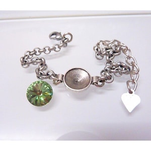 May include: A silver chain bracelet with a round silver charm and a green crystal charm.