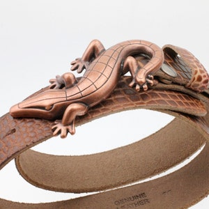 May include: A brown leather belt with a copper-coloured lizard buckle. The belt is made of genuine leather and has a crocodile-embossed pattern.