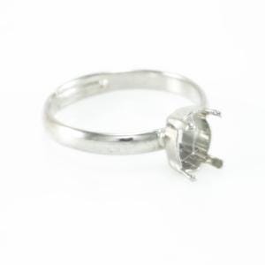 Peut inclure: Une bague argentée avec un sertissage à griffes, conçue pour accueillir une pierre précieuse. L'arrière-plan blanc met en valeur la brillance métallique et les détails du sertissage.