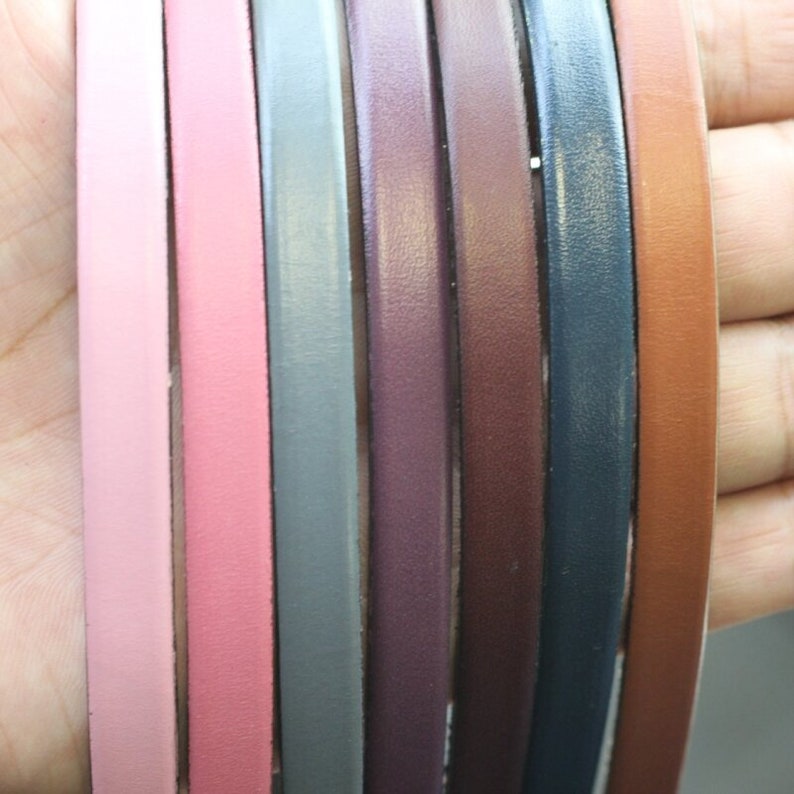 May include: Assortment of eight leather cords in various colors, including pink, gray, brown, and blue. The cords are arranged in a row, with the pink cords on the left and the blue cords on the right.