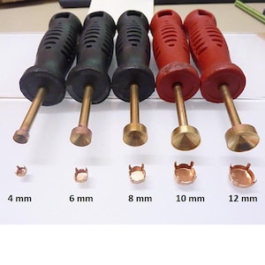 Könnte beinhalten: Fünf Einstellwerkzeuge mit schwarzen und roten Griffen und Messingspitzen, jede mit einer entsprechenden Größe der Zargenfassung: 4 mm, 6 mm, 8 mm, 10 mm und 12 mm.