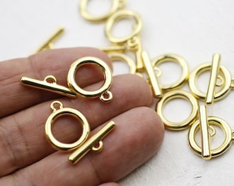 May include: Gold-toned metal toggle clasps with a round ring and a straight bar. The clasps are perfect for jewelry making, bag making, and other craft projects.