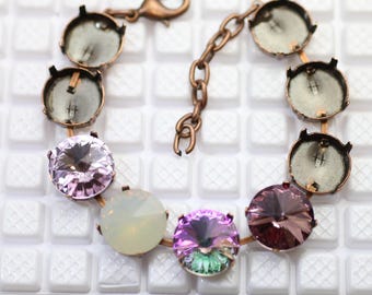 Könnte beinhalten: Ein kupferfarbenes Armband mit runden, lünettengefassten Kristallen in Lila, Rosa und schillerndem Grün. Das Armband enthält leere Lünetteneinstellungen und eine Kette mit einem Karabinerverschluss. Das Armband ist etwa 17.78 cm lang.