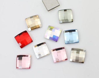 May include: Assortment of ten square-shaped rhinestones in various colours, including clear, silver, red, pink, blue, and iridescent.