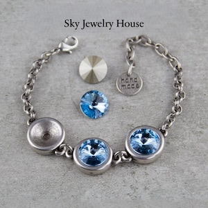 Peut inclure: Un bracelet en chaîne argentée avec trois accents de cristal bleu clair. Le bracelet a un fermoir et une petite étiquette qui dit "fait main".