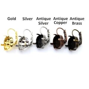 May include: Five metal earring settings in gold, silver, antique silver, antique copper, and antique brass. Each setting has a lever-back closure and a round bezel for holding a stone. Text above each setting indicates the metal type.