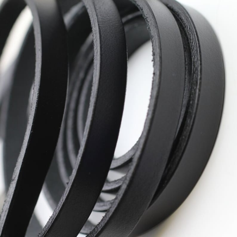 May include: Close-up of black leather straps, showing the texture and detail of the material.