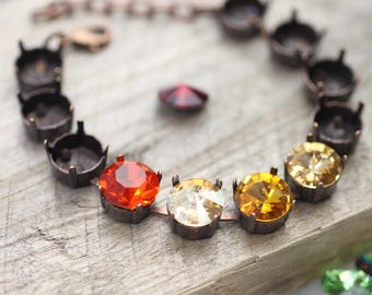 Könnte beinhalten: Ein Kupferarmband mit einem Kettenverschluss und einer Reihe runder, facettierter Edelsteine. Die Edelsteine sind in Orange-, Gelb- und Klar-Tönen.