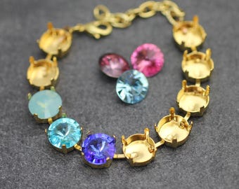 Könnte beinhalten: Ein goldenes Kettenarmband mit leeren Fassungen für Strasssteine. Das Armband ist von losen Strasssteinen in verschiedenen Farben umgeben, darunter rosa, blau und hellblau.