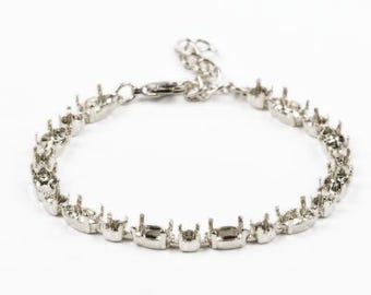 Könnte beinhalten: Silberarmband mit einer Reihe ovaler Fassungen für Steine. Das Armband hat einen Karabinerverschluss.