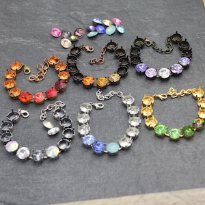 May include: Seven different bracelets with various colored rhinestones and metal settings. The bracelets are on a gray surface.