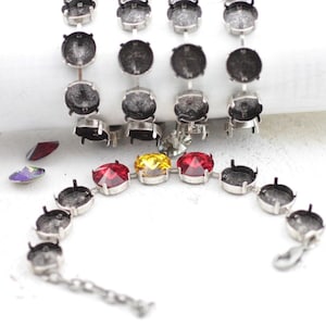 May include: A silver bracelet with a chain and round settings for rhinestones. The bracelet has three red, yellow, and clear rhinestones.