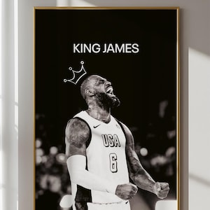 Könnte beinhalten: Schwarz-Weiß-Druck in einem goldenen Rahmen, der einen Basketballspieler im USA-Trikot mit der Nummer 6 zeigt. Der Text "KING JAMES" und eine Krone sind über dem Spieler abgebildet.
