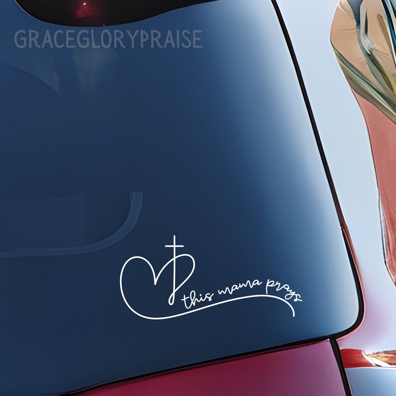 May include: White vinyl decal with a heart and cross design and the text "this mama prays".