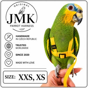 May include: A bright yellow parrot harness with a black buckle and a small black tag labelled JMK. The text on the image reads ORIGINAL JMK PARROT HARNESS, HANDMADE IN CZECH REPUBLIC, TRUSTED WORLDWIDE, SINCE 2020, MADE WITH LOVE, and SIZE: XXS, XS.