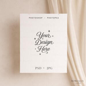 Puede incluir: Un letrero rectangular blanco con el texto "PHOTOSHOP + PHOTOPEA" en la parte superior y "PSD + JPG" en la parte inferior. Las palabras "Your Design Here" están en el centro, con acentos de estrella. El letrero cuelga sobre un fondo neutro.