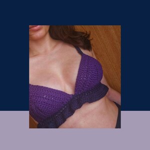 May include: Purple crochet bra top with a ruffled trim. The bra top is made with a delicate stitch pattern.