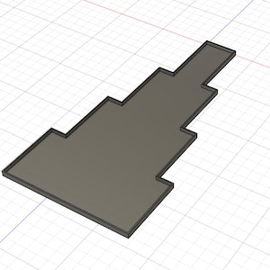 Puede incluir: Objeto rectangular gris renderizado en 3D con un dise&ntilde;o escalonado. El objeto tiene un borde gris oscuro y se encuentra sobre un fondo de cuadr&iacute;cula. La forma recuerda a una alfombra de suelo o una pieza cortada a medida.