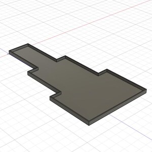 Puede incluir: Objeto rectangular gris renderizado en 3D con un dise&ntilde;o escalonado. El objeto tiene un borde elevado alrededor de su per&iacute;metro, creando un borde definido. El fondo presenta un patr&oacute;n de cuadr&iacute;cula.