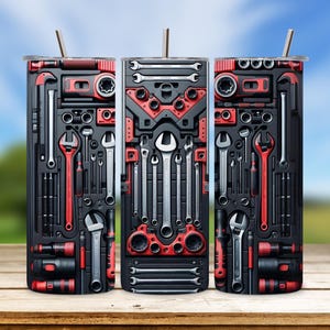 Op de afbeelding: Drie roestvrijstalen bekers met een rood en zwart ontwerp met verschillende gereedschappen. De bekers zijn in een rij op een houten oppervlak geplaatst.