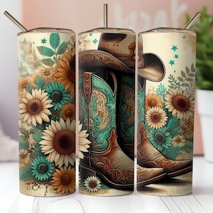 May include: A set of three stainless steel tumblers with lids and straws. Each tumbler features a design of cowboy boots, a cowboy hat, and sunflowers in shades of brown, turquoise, and yellow. The tumblers are decorated with floral and western-themed illustrations.
