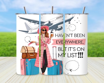 May include: A white travel tumbler with a straw, featuring a cartoon illustration of a woman in a pink coat, luggage, and an airplane. Text reads, "Haven't been everywhere, but it's on my list!!!"
