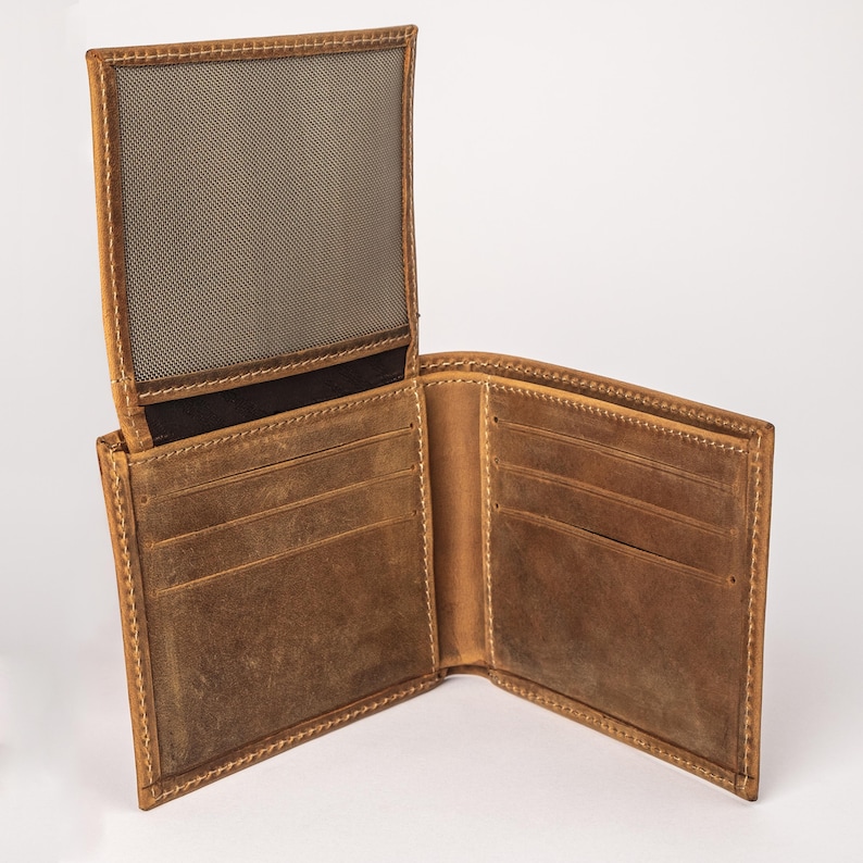 May include: Open, brown leather wallet with multiple card slots and a mesh ID window. The wallet is made of distressed leather and features visible stitching around the edges. The wallet is open, displaying its interior compartments.