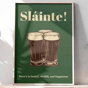 Może przedstawiać: Zielony plakat z tekstem "Sl&aacute;inte!" w kolorze kremowym. Pod tekstem przedstawiono trzy szklanki ciemnego piwa. Tekst "Here's to health, wealth, and happiness" znajduje się na dole plakatu.