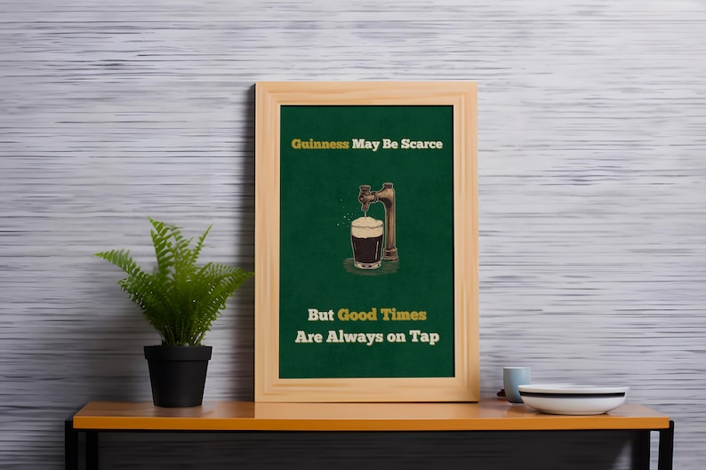 May include: A framed green poster with the text "Guinness May Be Scarce But Good Times Are Always On Tap". The poster features a cartoon illustration of a beer tap pouring a glass of Guinness.