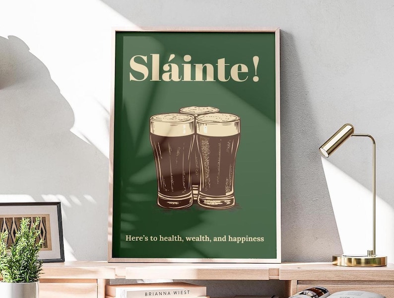 May include: A green poster with the text "Sl&aacute;inte!" in a white font. The poster features a drawing of four glasses of dark beer with the text "Here's to health, wealth, and happiness" at the bottom.