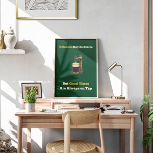 May include: A green and white poster with the text "Guinness May Be Scarce But Good Times Are Always On Tap". The poster features an illustration of a pint of Guinness being poured from a tap.