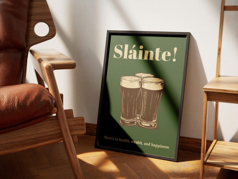 Może przedstawiać: Zielony plakat z tekstem "Sl&aacute;inte!" w ż&oacute;łtym kolorze. Trzy szklanki ciemnego piwa są ułożone jedna na drugiej. Tekst "Here's to health, wealth, and happiness" znajduje się na dole plakatu.