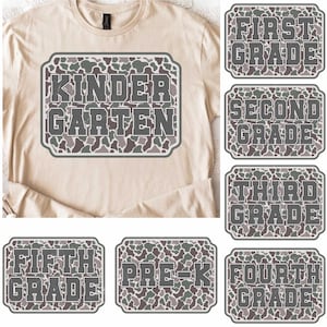May include: A beige long-sleeved t-shirt with a large rectangular graphic that says "KINDERGARTEN" in gray letters with a camouflage pattern. Additional graphics for First, Second, Third, Fourth, Fifth Grade, and Pre-K are also shown.