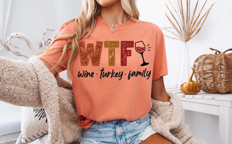 May include: A peach colored t-shirt with the text "WTF Wine - Turkey - Family" and a glass of wine graphic.