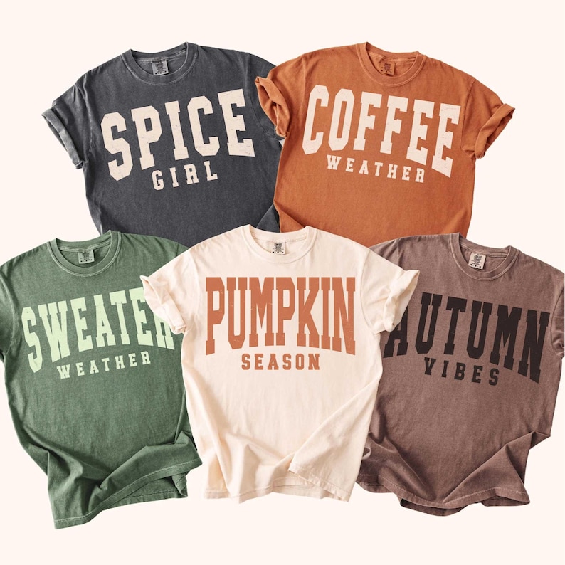 May include: Five short-sleeved t-shirts in various colors, each with a different fall-themed phrase in bold, white or orange lettering. Phrases include "Spice Girl," "Coffee Weather," "Sweater Weather," "Pumpkin Season," and "Autumn Vibes."