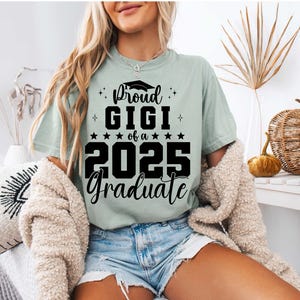 K&ouml;nnte beinhalten: Ein hellgr&uuml;nes T-Shirt mit schwarzem Text, der "Proud Gigi of a 2025 Graduate" lautet. Der Text enth&auml;lt ein Abschlusskappen-Symbol.