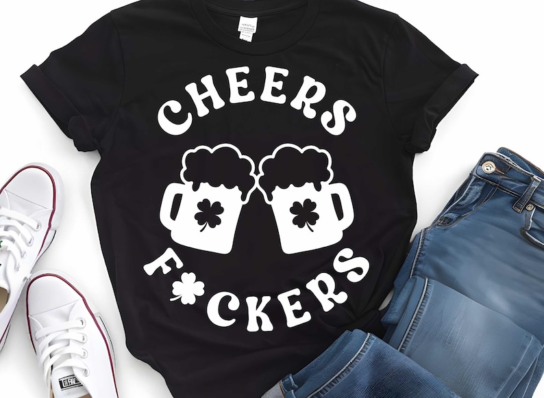 May include: Black t-shirt with white text that reads "Cheers F*ckers" and a graphic of two beer mugs with shamrocks.