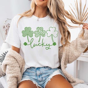 May include: White t-shirt with a green shamrock design and the word "lucky" printed on it.