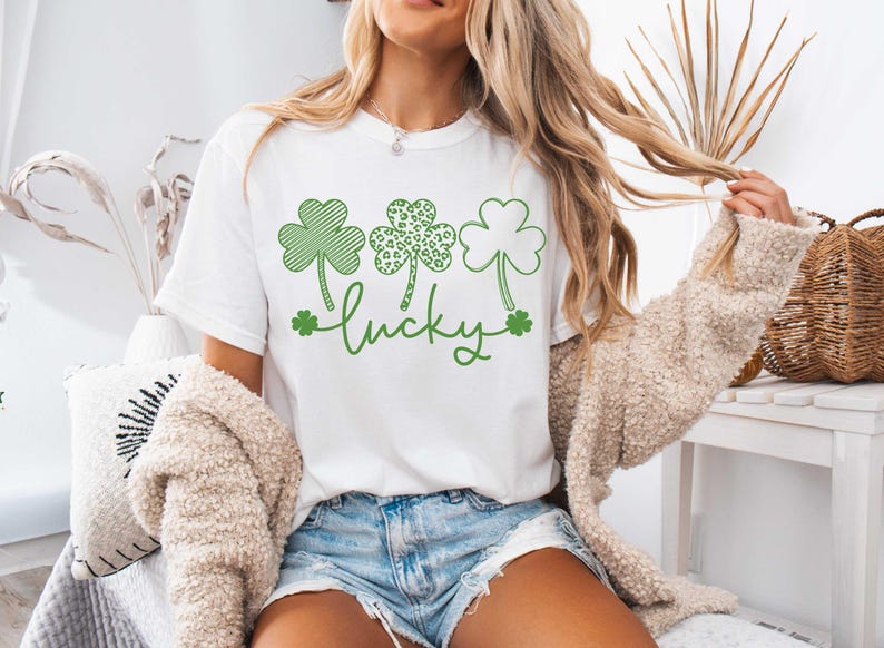 May include: White t-shirt with a green shamrock design and the word "lucky" printed on it.
